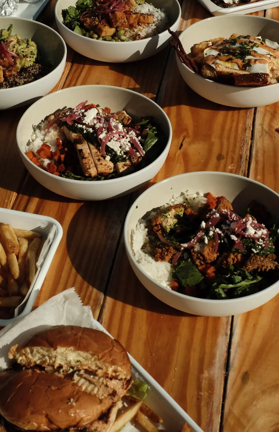 Bowls and sandwiches across a wooden table